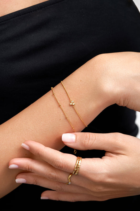 Gold jewellery stack on wrist