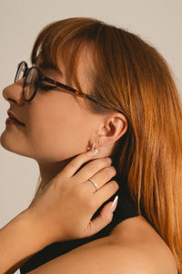dainty diamond bar studs in sterling silver on model with other jewellery