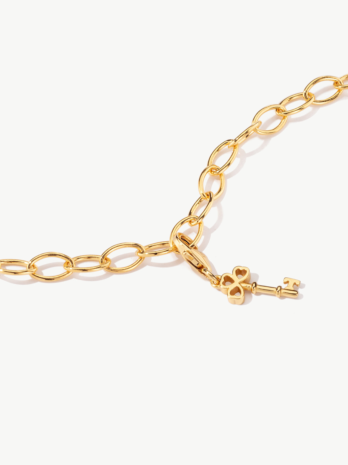 gold key charm on bracelet