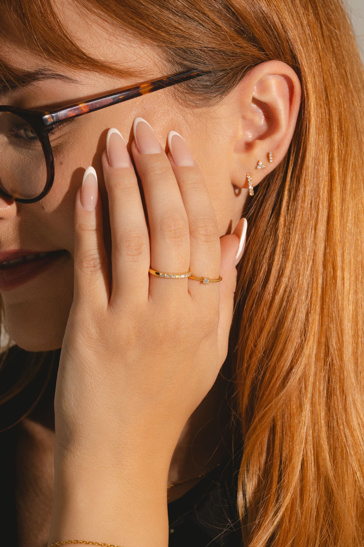 Woman wearing 18ct gold vermeil earring and ring stack with lab grown diamonds