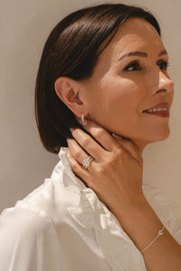 Model wearing pair of sterling silver Delphine nature detail hoop earrings
