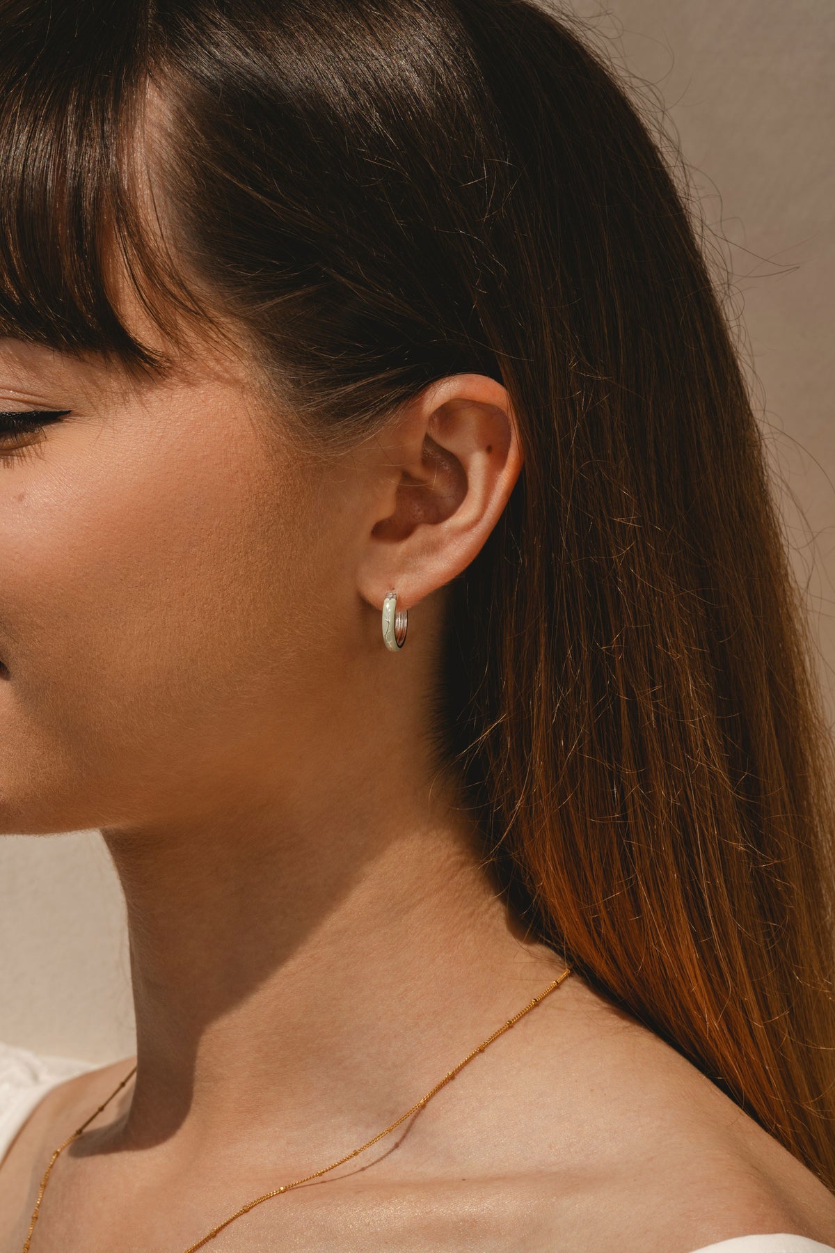 Model wearing Ophelia enamel hoop earrings with nature detail 