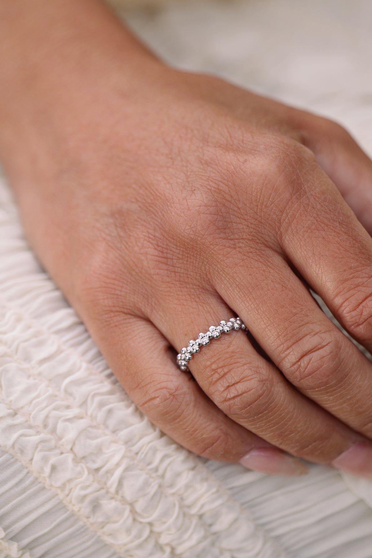 Close-up of a hand wearing a beaded ring in sterling silver