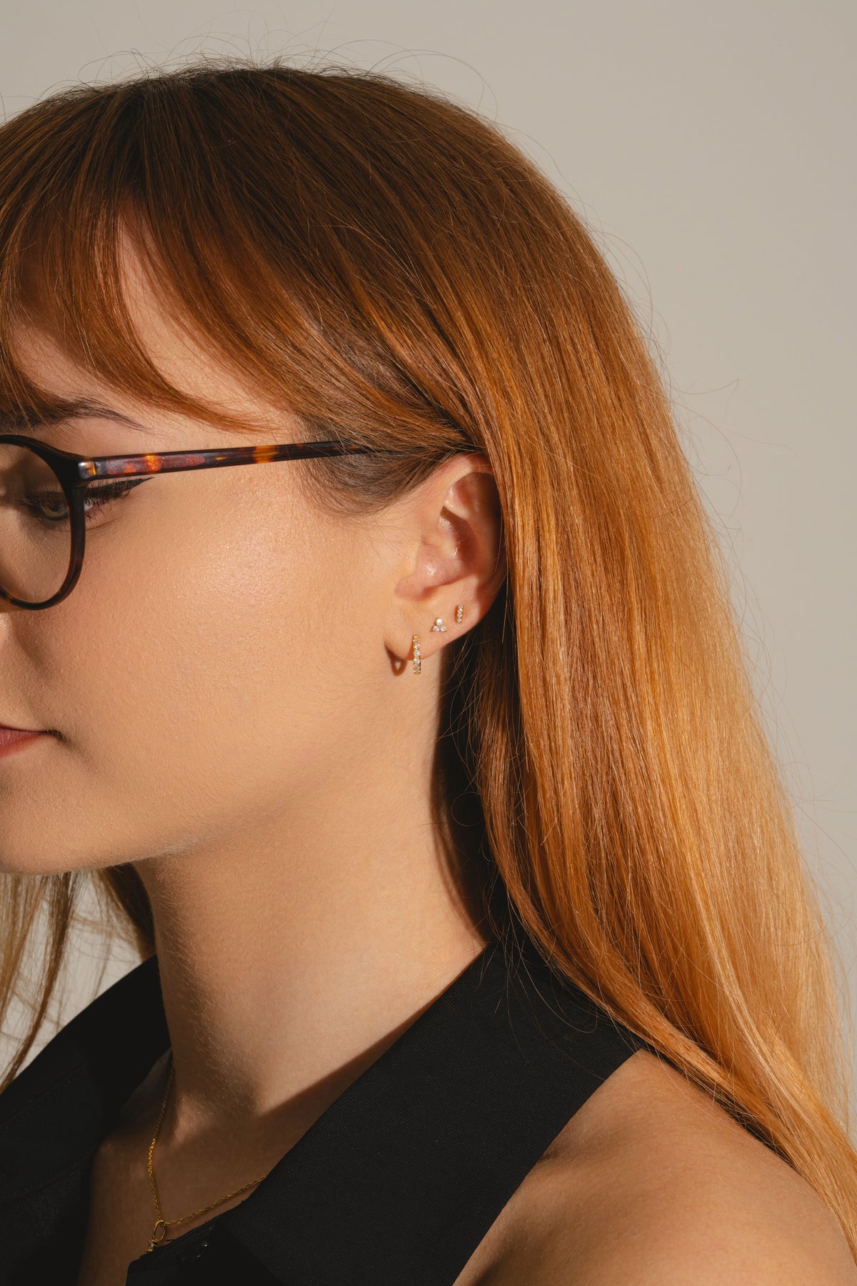 Dainty diamond bar studs in god vermeil with other earrings on model