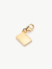 enamel book charm in gold on surface
