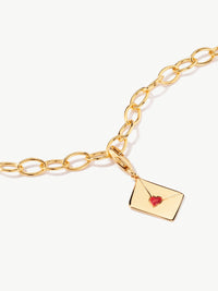 enamel letter charm with red heart on bracelet in gold