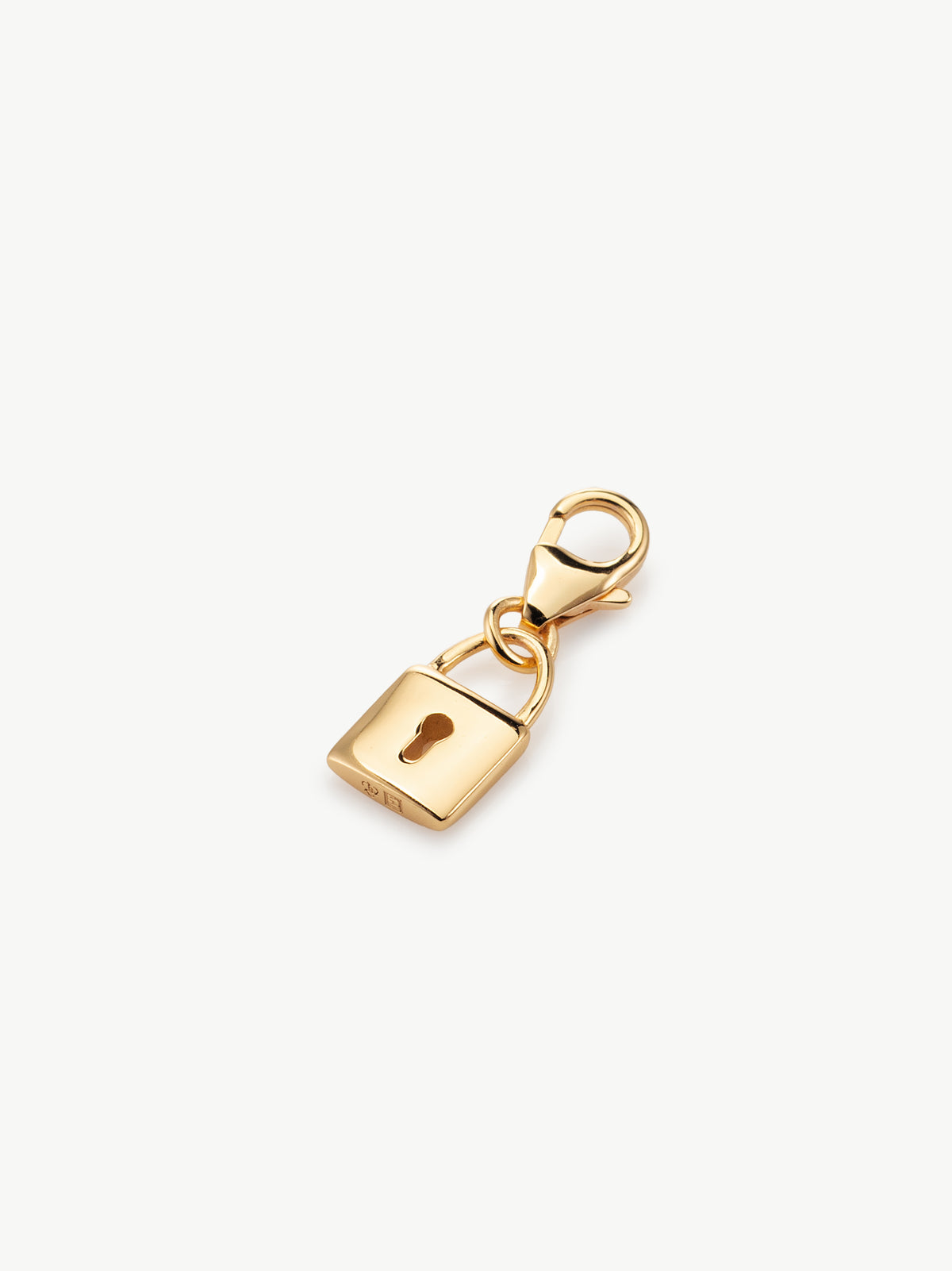 lock charm in gold laying flat