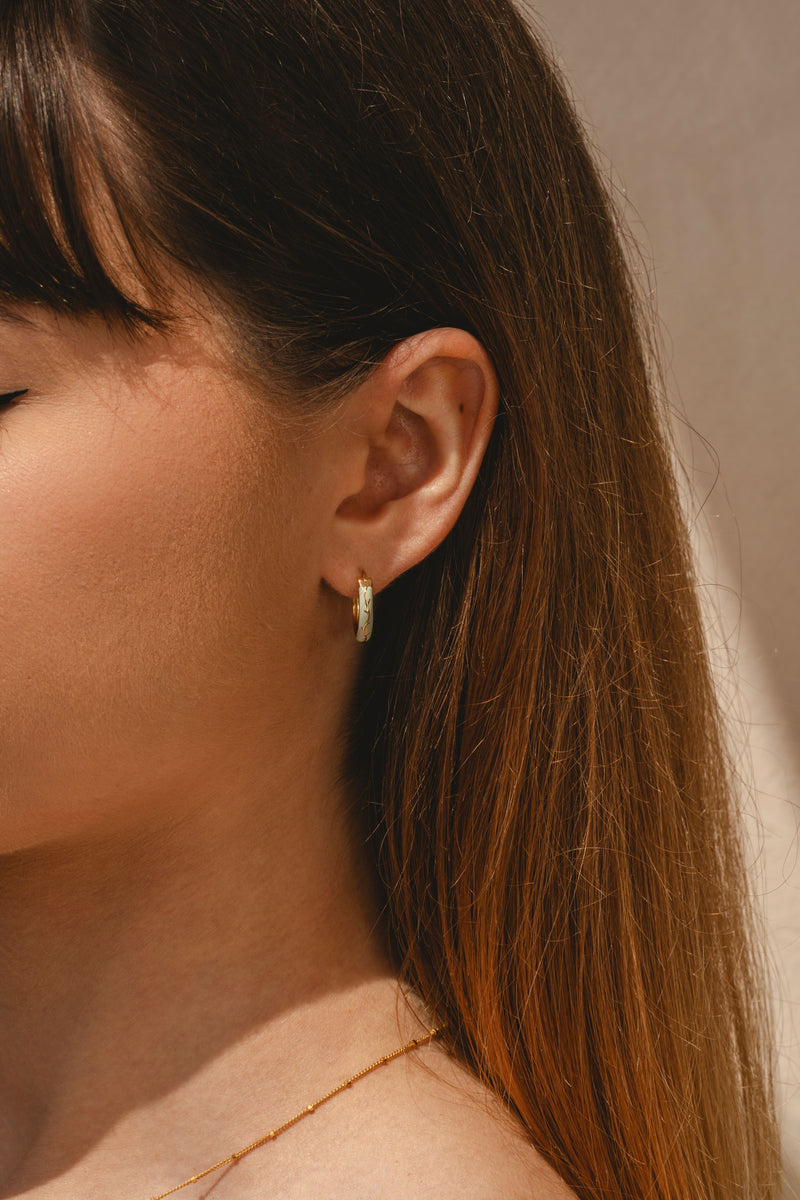 model wearing Pair of gold vermeil Ophelia enamel hoop earrings with nature detail 