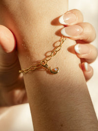model wearaing moon charm with moonstone on bracelet in gold 